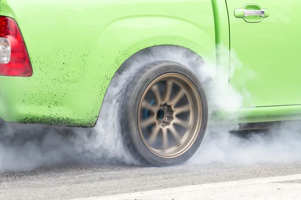 Race car burns rubber off its tires in preparation for the race