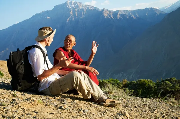 Tourist and monk in mountains