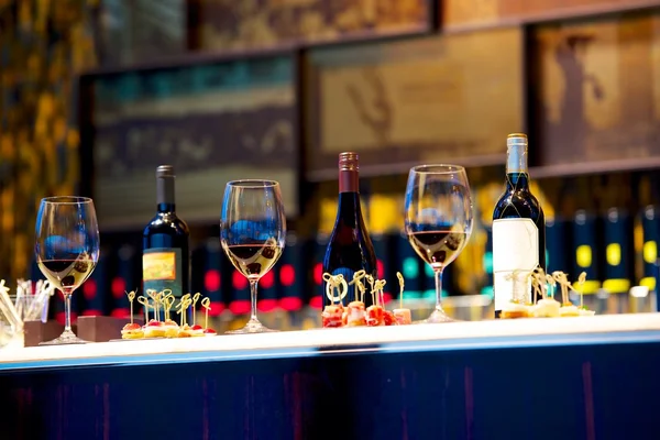 Snacks and glasses of wine on counter