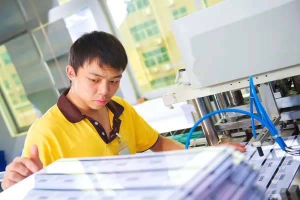 Chinese worker on plastic card production factory