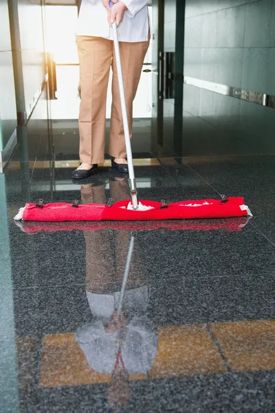 Worker is cleaning the floor in an office building