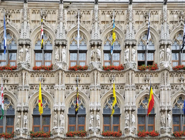 Medieval gothic architecture of Grand Place in Leuven, Belgium with flags of Belgian provinces
