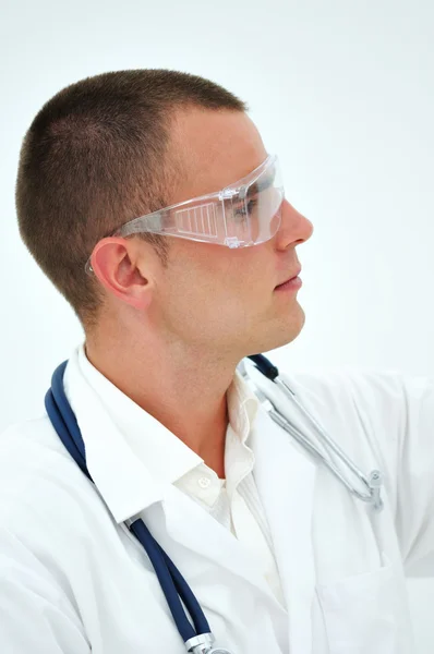 Young doctor watching samples through safety glasses