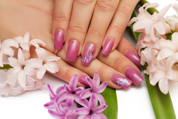 Woman hands with manicured nails and flowers