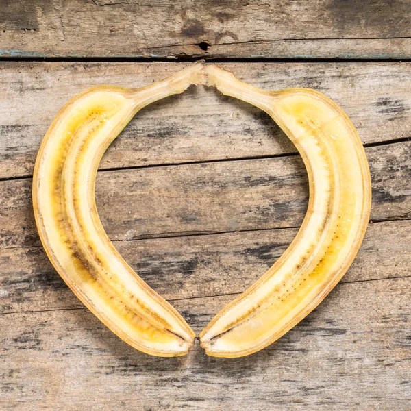 Cut in Half Banana lying on Textured Weathered Wooden Table