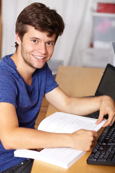 Young handsome guy with laptop and book, background