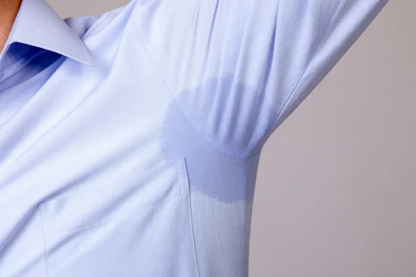 Man with hyperhidrosis sweating very badly under armpit in blue