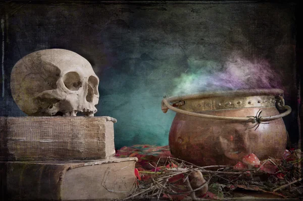 Old skull on old book and copper cauldron