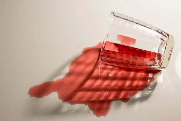 Spilled red grape juice glass floor