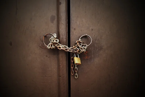 Antique key lock chain on wooden box.