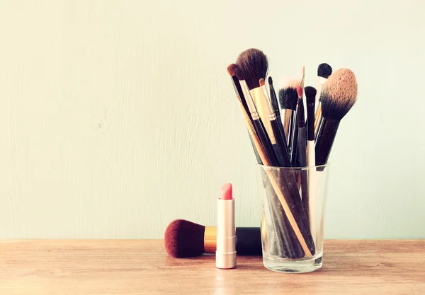 Make up brushes over wooden table