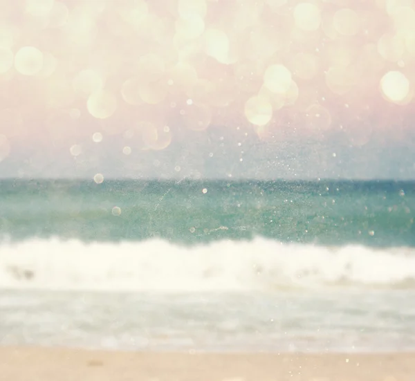 Background of blurred beach and sea waves with bokeh lights, vintage filter.