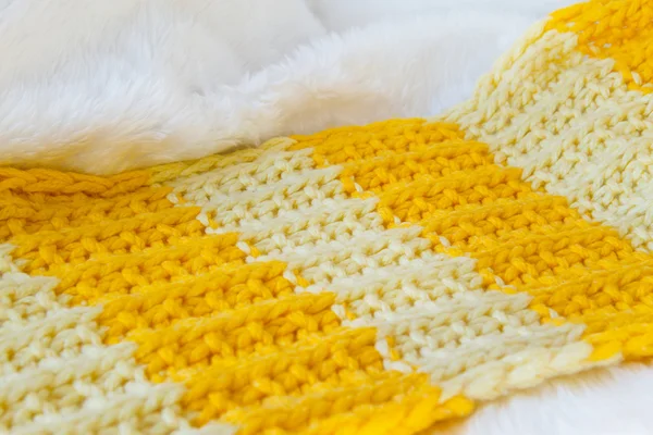 With white fur Texture of a knitted cloth of brightly yellow and orange color, in a strip