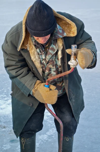 Old man on winter fishing