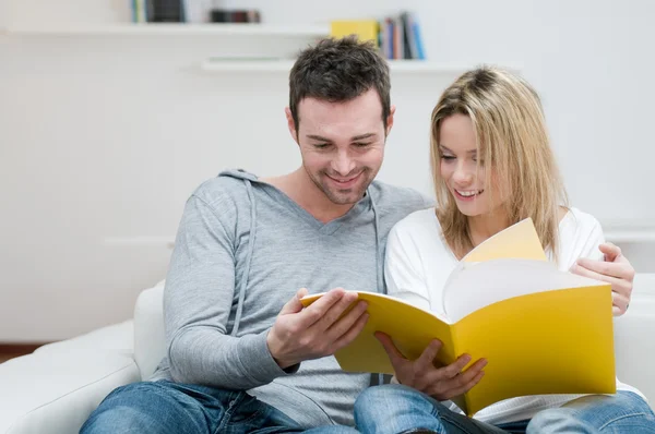 Young couple reading magazine