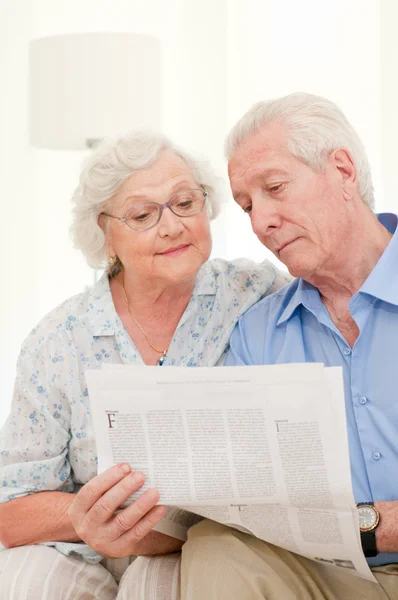 Aged couple reading news