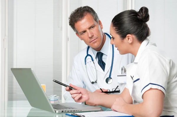Doctor and nurse working at laptop