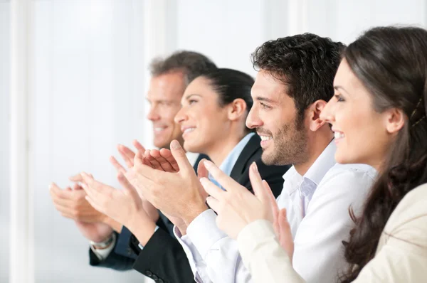 Happy business team clapping hands