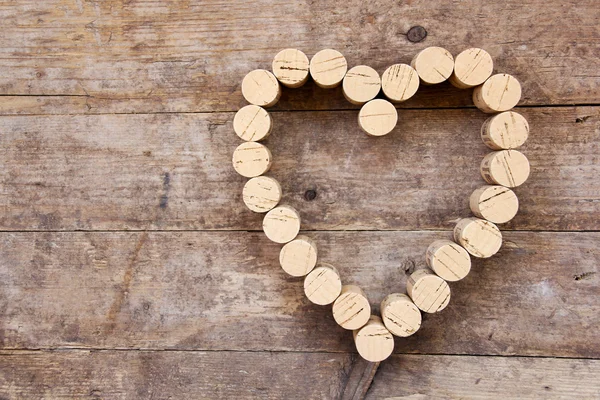 Wine corks form a heart shape on the wood board