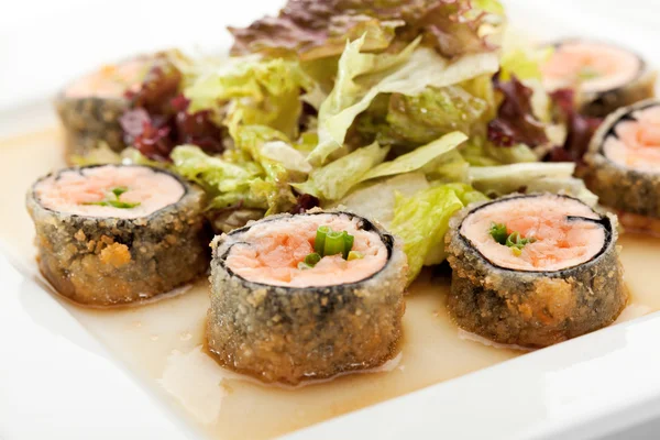 Japanese Cuisine - Deep-fried Sushi Roll with Salmon and Lettuce inside. Served with Salad Leaf and Sauce