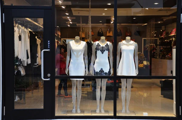 Boutique display window with mannequins in fashionable dresses