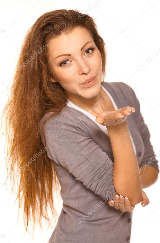 Closeup of flirtatious young woman pouting over white background