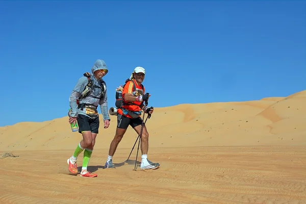 Two unidentified runners running in desert