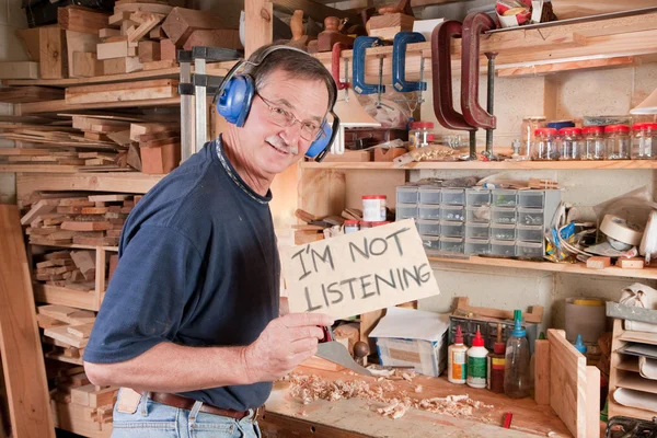 Senior man in workshop not listening