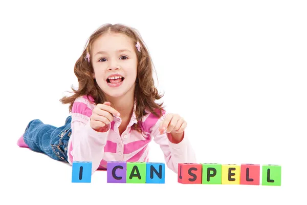 Girl with kids blocks saying I can spell