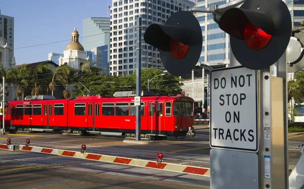 Downtown Scene at RailRoad Crossing Red Trolley Car Passing Sign