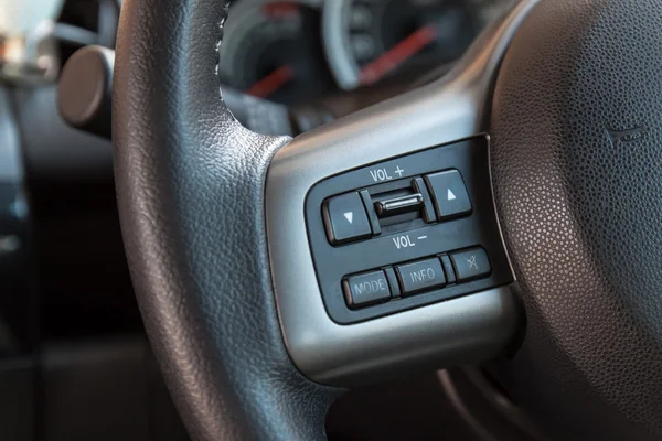 Audio control buttons on steering wheel of car