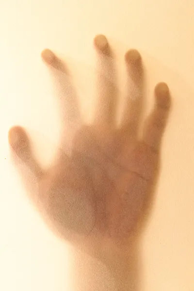 Scary palm of hand behind mirror in the bathroom