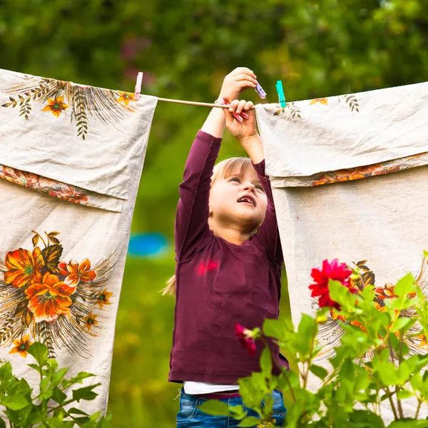 Sweet five-year girl with clothespin and the clothesline