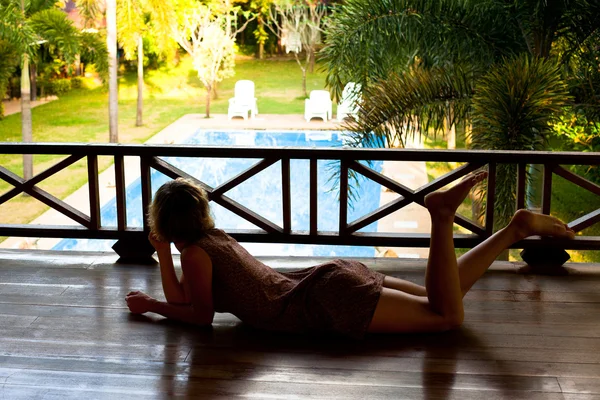 Young woman lying down looking at the pool in the spa resort