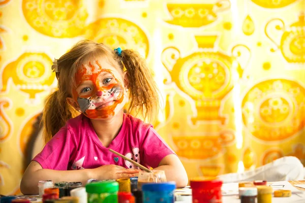 Little child, drawing paint with paint of face