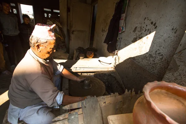 Unidentified Nepalese man working in the his pottery workshop