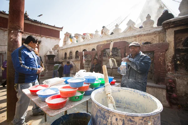 Unidentified man sell cement for donations for repairs near stupa Boudhanath