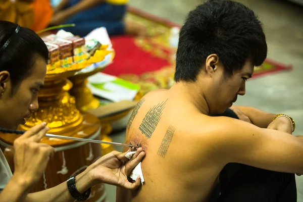 Unidentified monk makes traditional Yantra tattooing