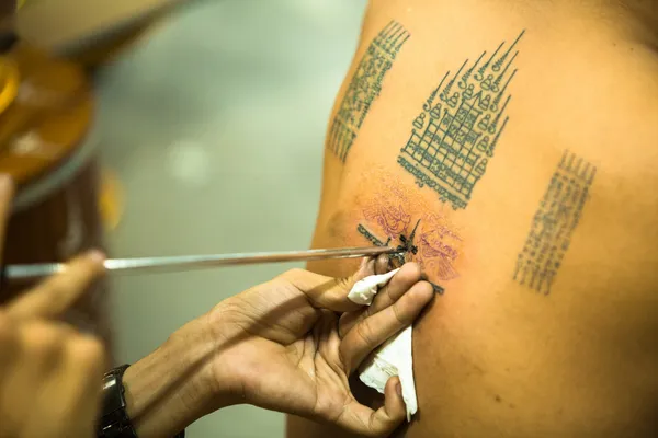 Unidentified monk makes traditional Yantra tattooing