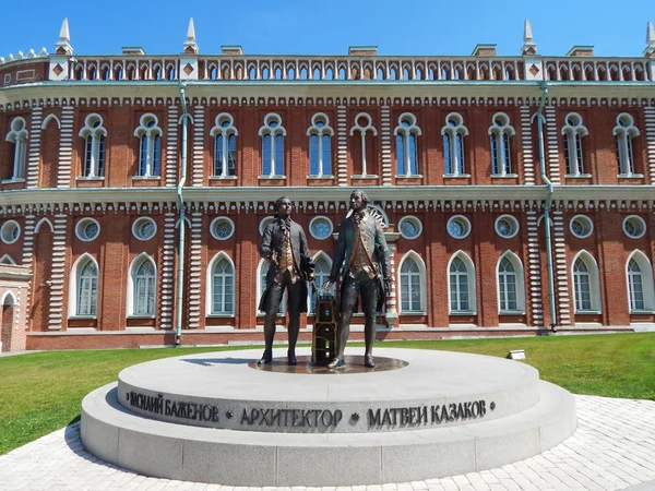 A monument to two famous Russian architects - Vasily Bazhenov and Matvey Kazakov - against the Bread Building (Kitchen Building.)Tsaritsyno museum and reserve. Tsaritsyno park. Moscow. July, 2014.