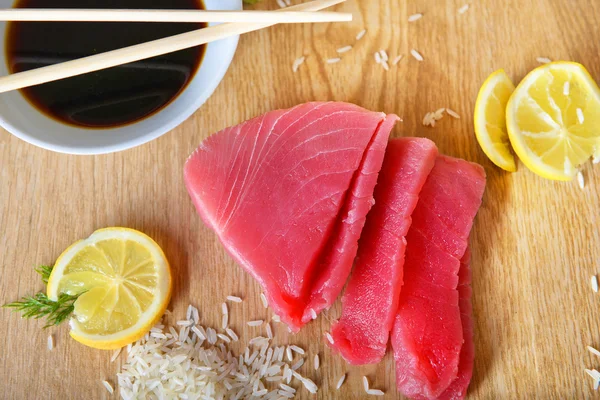 Fresh tuna with rice and lemon on the table