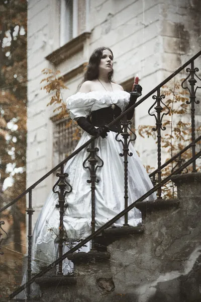 Mysterious woman in Victorian dress. Stylized photo at old