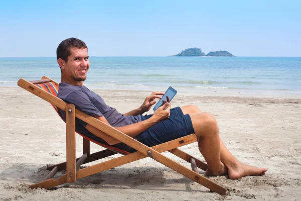 Business man with tablet on the beach