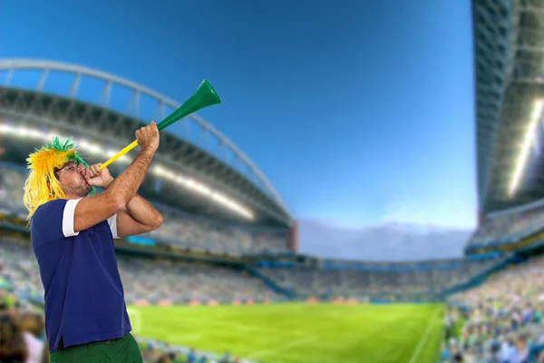 Brazilian fan at stadium playing vuvuzela
