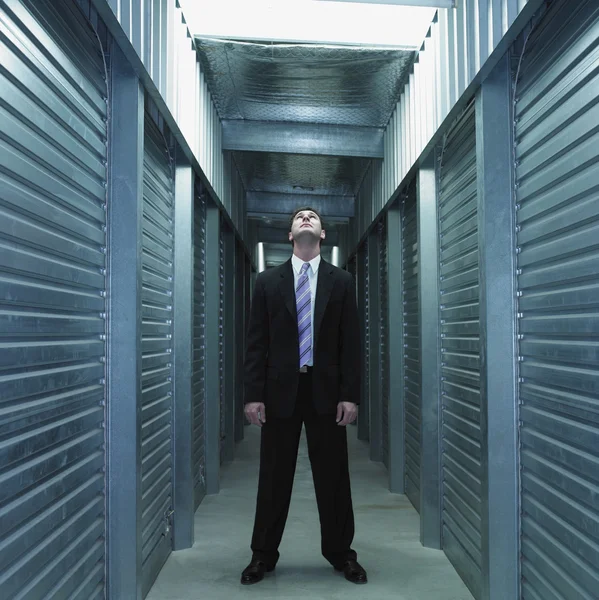 Businessman standing in storage unit hallway