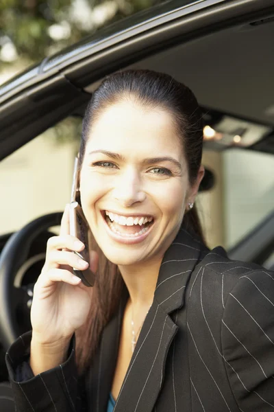 Businesswoman talking on cell phone in car