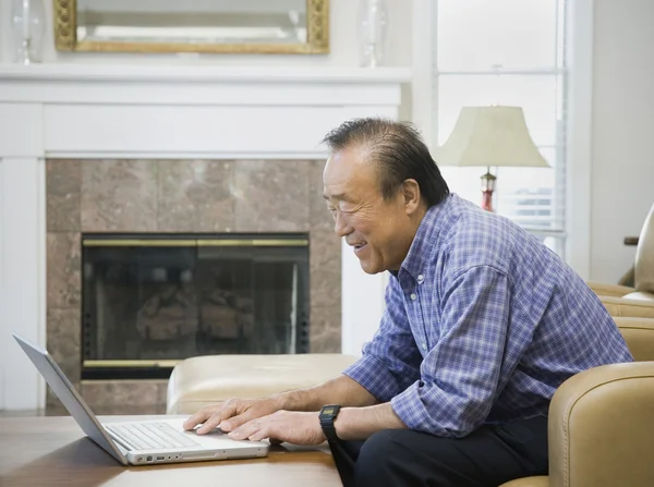 Senior Asian man looking at laptop