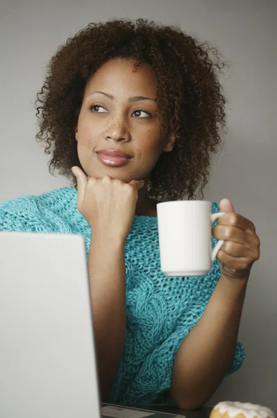 Woman with laptop and cup of coffee