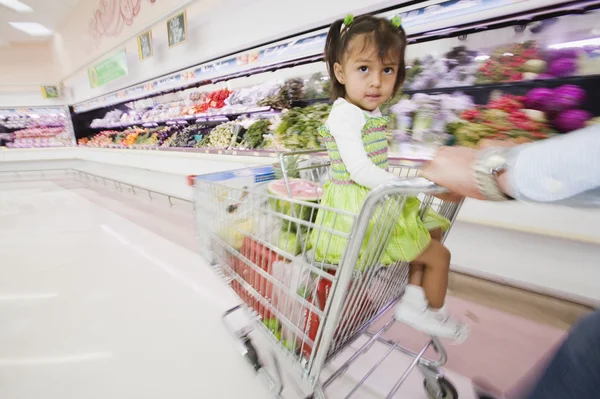Hispanic girl in shopping cart