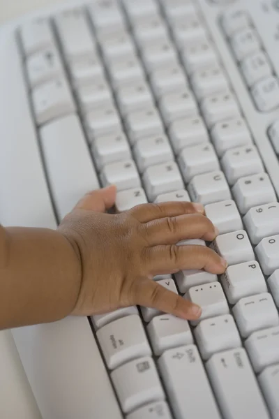 Close up of Hispanic baby\'s hand on computer keyboard